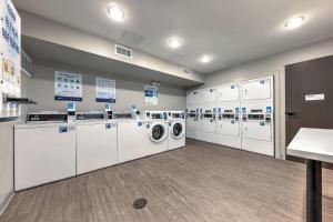 a laundry room with white washers and dryers at ECHO Suites Extended Stay by Wyndham Dallas Plano Richardson in Plano