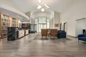 a lobby with a library with chairs and a table at La Quinta Inn by Wyndham Vancouver Airport in Richmond