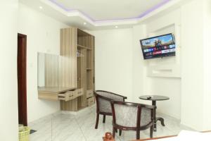 a room with two chairs and a table and a tv at Regency Park Hotel in Mombasa
