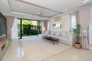 a living room with a white couch and a table at Luxury 5 bed Laguna Park no Pool in Bang Tao Beach