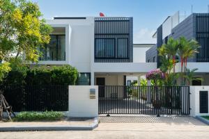 a white house with a black fence and trees at Luxury 5 bed Laguna Park no Pool in Bang Tao Beach