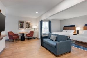 a hotel room with a bed and a couch at Hampton Inn Owensboro in Owensboro +34 photos