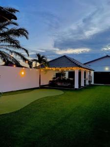 a backyard of a house with a green lawn at Sanyan Retreat in Jeram