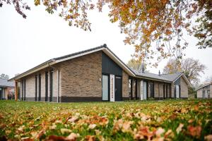 a brick school building with a grass yard at De IJsvogel - Het échte Veluwegevoel in Voorthuizen