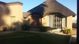 mały domek z trawnikiem przed nim w obiekcie Kleinplaas Guest Farm w mieście Potchefstroom