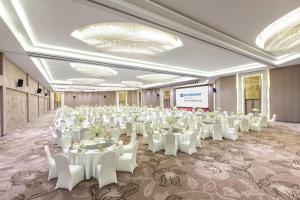 a banquet hall with white tables and white chairs at Wyndham Lijiang Yulong in Lijiang +106 photos