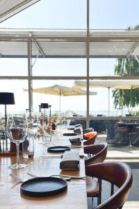 a long table with chairs and plates and wine glasses at Hotel Faaborg Fjord in Faaborg