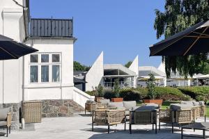 a patio with chairs and tables in front of a building at Hotel Faaborg Fjord in Faaborg