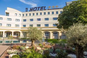 un hôtel avec un jardin en face d'un bâtiment dans l'établissement Hotel Le Paddock, à Magny-Cours