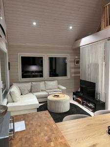 a living room with a white couch and a tv at Villa Mustikkamaa in Lohja +22 photos