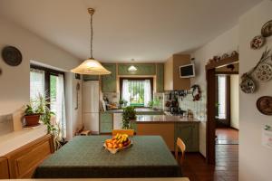 a kitchen with a table with a bowl of fruit on it at Alle Robinie in Pradamano