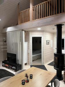 a living room with a loft with a bed and a table at Villa Mustikkamaa in Lohja