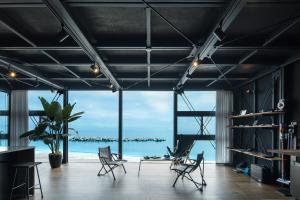 a room with chairs and a view of the ocean at Yokosuka Sky Grey -横須賀のビーチフロントベース- in Yokosuka