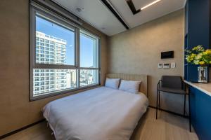 a bed in a room with a large window at Nampo Stay 99 in Busan