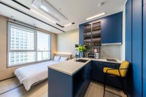 a room with a bed and a kitchen with a sink at Nampo Stay 99 in Busan