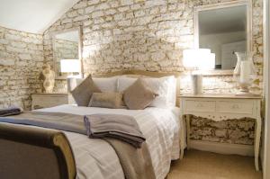 a bedroom with a bed and a stone wall at Scotney Place in Stamford