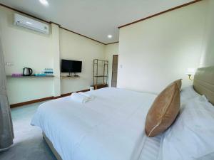 a bedroom with a white bed and a television at Libong River View in Ban Maphrao (2)