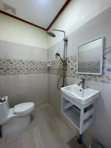 a bathroom with a sink and a toilet and a mirror at Libong River View in Ban Maphrao (2)