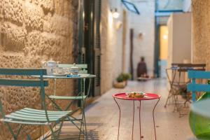 a table with two chairs and a plate of food on it at La Luna In Cortile in Lecce
