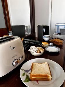 a piece of toast on a plate next to a toaster at Kiki's Rooms 2 in Vlorë