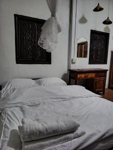 a bed with white sheets and a dresser in a bedroom at Heuan kuuma in Nongkhiaw