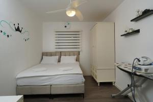 a small bedroom with a bed and a desk at S Villa Place נהריה in Nahariyya +44 photos