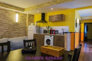 a kitchen with a stove, microwave, and refrigerator at Apartamentos Adarve Toledo in Toledo