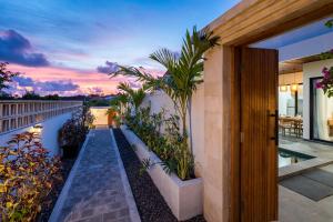 a house with a pathway with plants on a balcony at Diwangkara Villa Pandawa in Ungasan