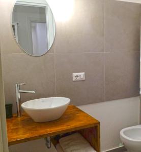 uma casa de banho com um lavatório branco e um espelho. em B&B Acqua di Sale em Manfredonia