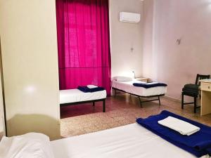 a room with two beds and a pink curtain at 6 Small rooms in Naples