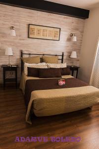 um quarto com uma cama grande e 2 mesas de cabeceira em Apartamentos Adarve Toledo em Toledo