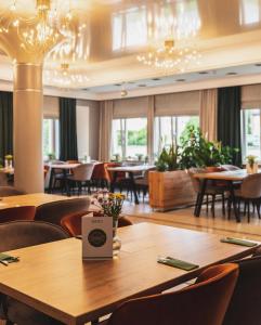 a restaurant with wooden tables and chairs and windows at Diament in Nowa Ruda