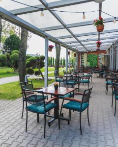 a patio with tables and chairs under a pergola at Diament in Nowa Ruda
