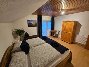 a bedroom with two beds and a wooden cabinet at Ferienwohnung Bergherz in Sankt Johann im Walde