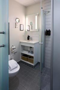 a bathroom with a shower and a toilet and a sink at Hotel Faaborg Fjord in Faaborg +34 photos