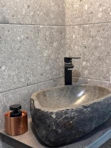 a large stone sink in a bathroom with a facet at RUSKA-mökki in Tyrnävä