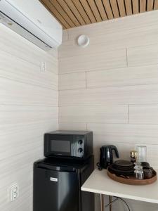 a microwave sitting on top of a refrigerator at RUSKA-mökki in Tyrnävä