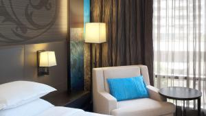 a room with a bed and a chair and a table at Paradox Bangkok Sukhumvit in Bangkok +59 photos