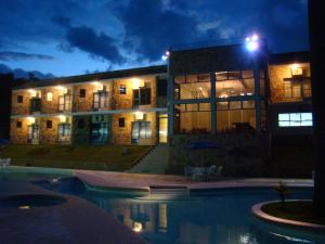 a building with a pool in front of it at night at Camping Quedasdagua in Itu