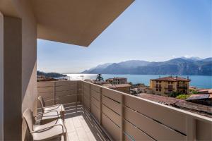 a balcony with two chairs and a view of the water at Hotel Diana in Malcesine