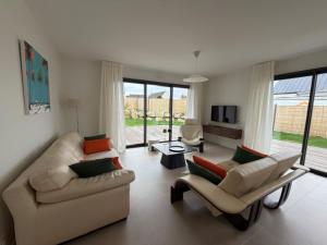 a living room with two couches and a television at Ty Rosc'OFF, Plain-pied de charme, tout récent, à proximité immédiate du centre de Roscoff in Roscoff