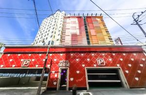 a red building in front of a tall building at 센스모텔 in Sasang-yŏk