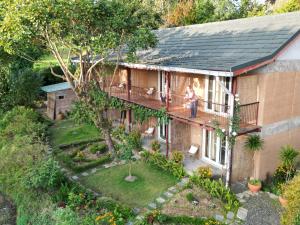 a woman standing on the balcony of a house at Resort Vishuddhialaya Pvt Ltd in Dhulikhel