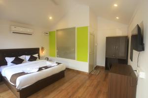 a bedroom with a bed and a flat screen tv at Molly's Nest in Mandrem