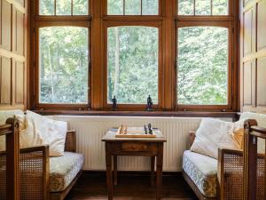 a room with two chairs and a table and windows at Beautiful castle in Spa wit garden in Spa