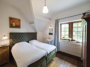 a bedroom with a bed and a sink and a window at Beautiful castle in Spa wit garden in Spa
