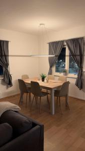 a dining table and chairs in a living room at Kirkenes down town apartments in Kirkenes
