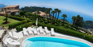 a resort with a pool and chairs and a house at Villa Favara in Scala