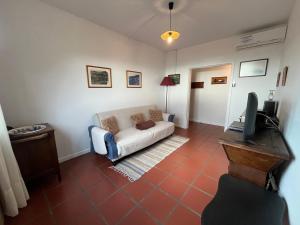 a living room with a couch and a tv at Casa do Arco in Arco da Calheta +17 photos