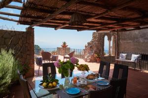 a table with food and flowers on a patio at Villa Favara in Scala